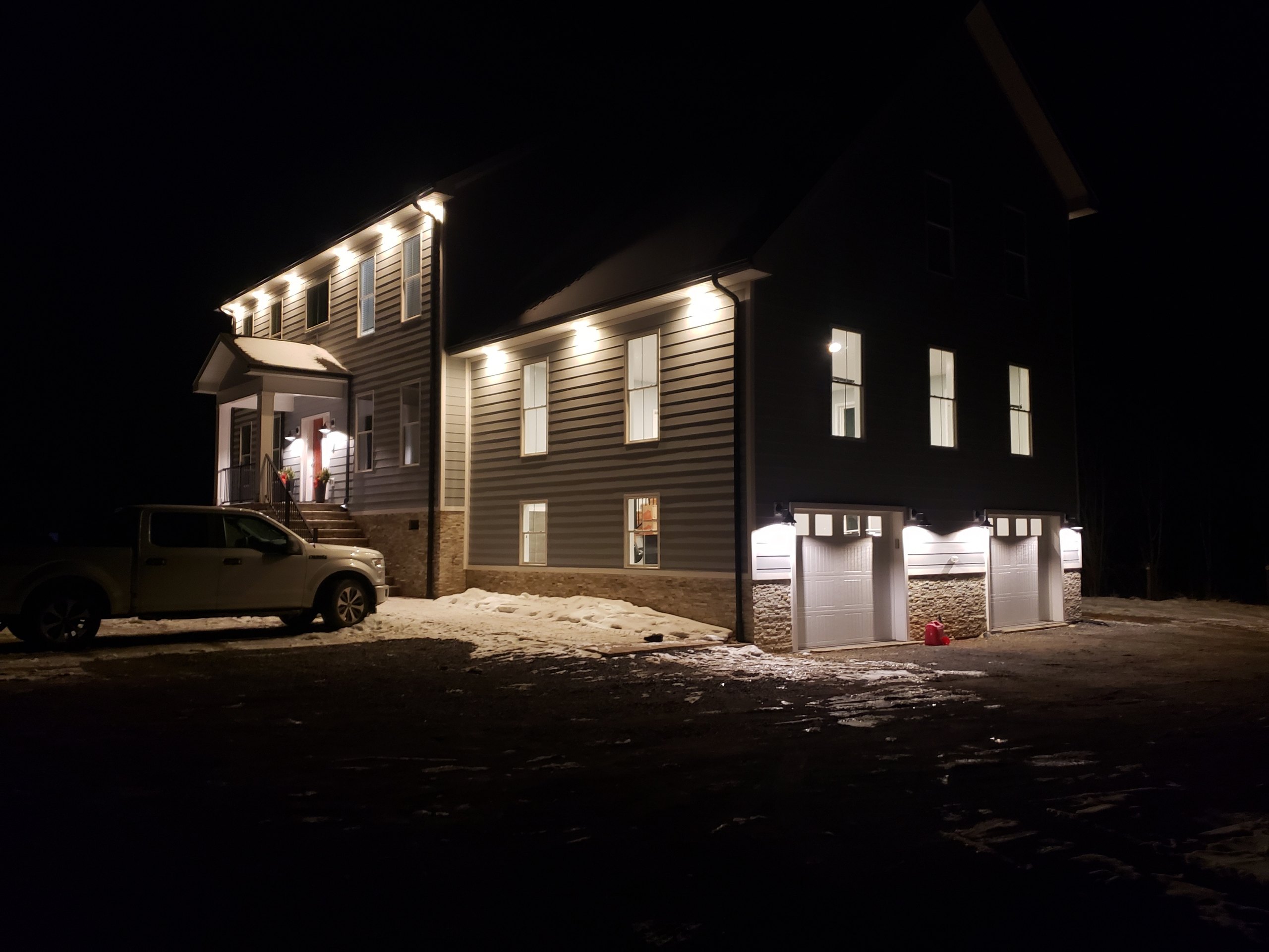 Exterior of a newly built home lit up at night